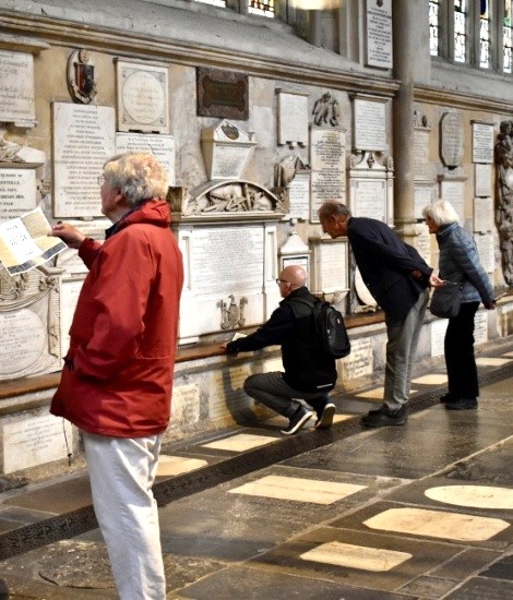 'Frolickers' investigating memorial plaques at Bath Abbey